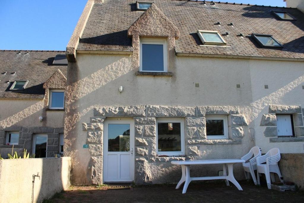 une maison avec une table et deux chaises devant elle dans l'établissement 704 - Belle maison au Domaine de LANRUEN, résidence privée face à la plage, à Le Val