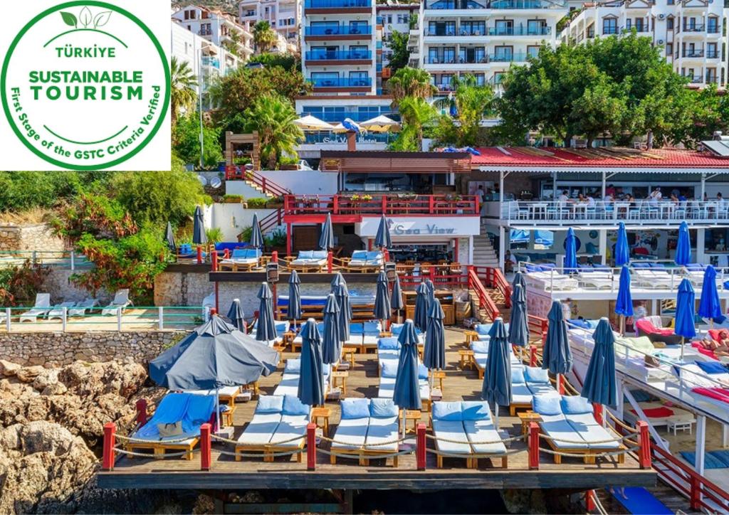 a group of lounge chairs and umbrellas on a dock at Sea View Hotel in Kaş