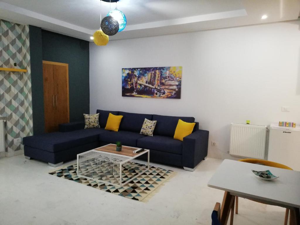 a living room with a blue couch and a table at appartement florence in Tunis