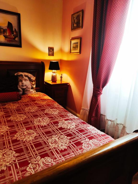 a bedroom with a bed with a red and white comforter at Real Santo António Guest House in Tarouca