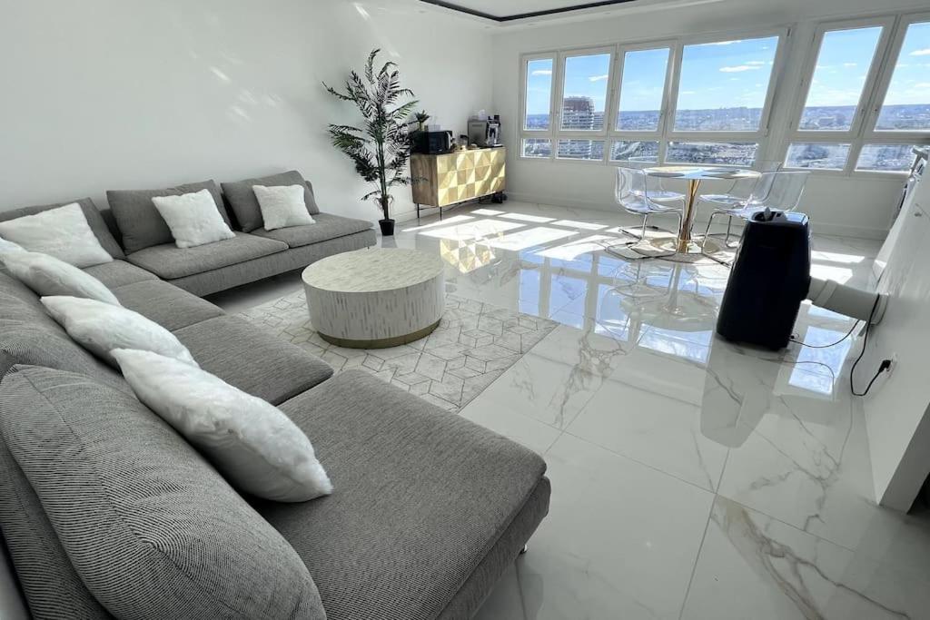 un salon avec un canapé et une table dans l'établissement Nice Apartment with amazing view of Paris + Parking, à Paris