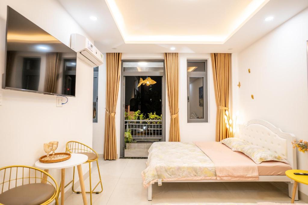 a bedroom with a bed and a table and chairs at The Sophia Apartment - Thao Dien Central in Ho Chi Minh City