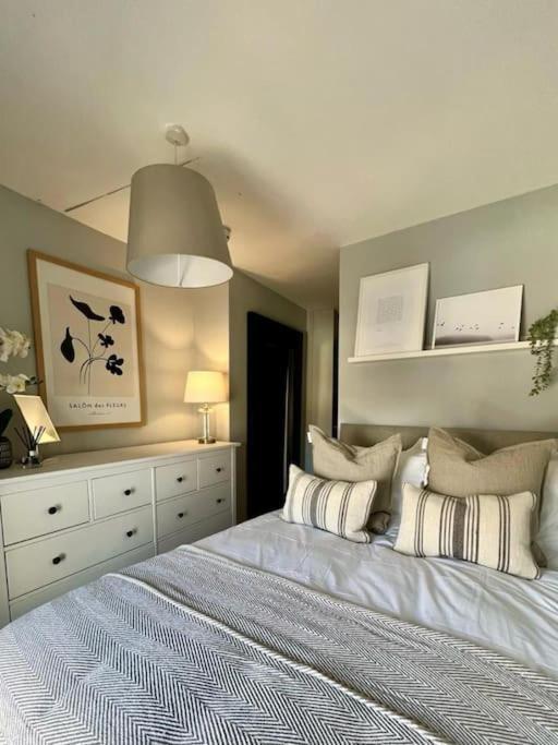 a bedroom with a white bed with pillows on it at Guest Homes - Rice Lane Retreat in Walton on the Hill