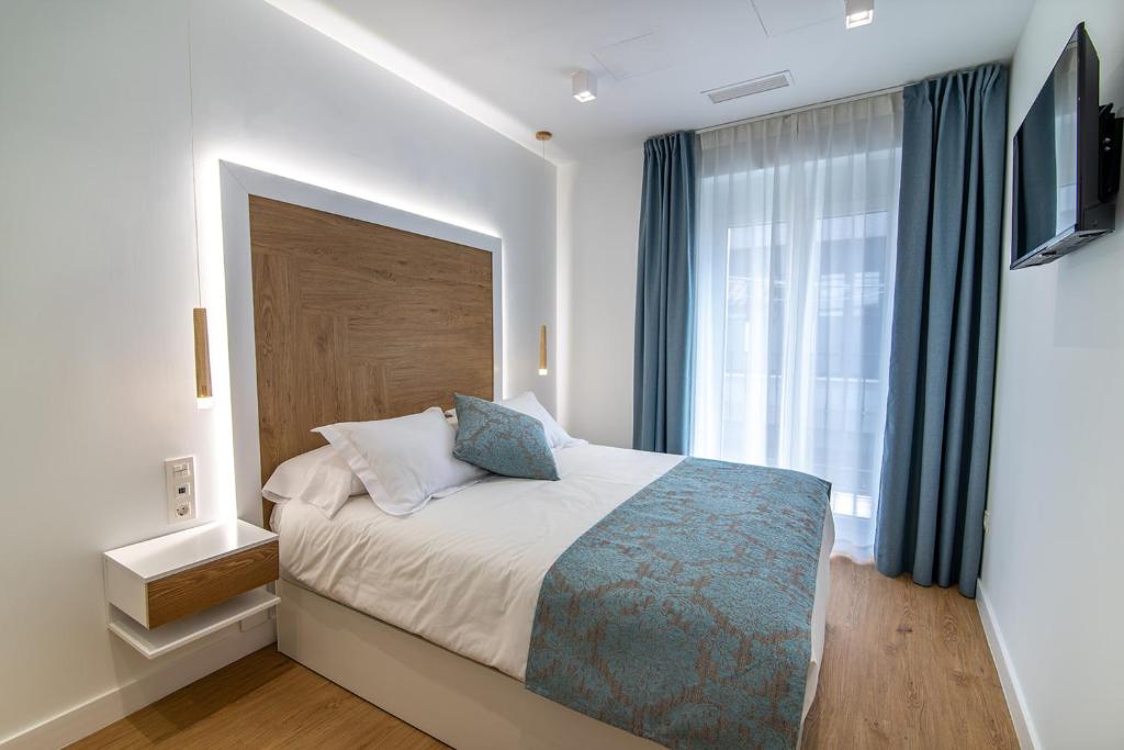 a bedroom with a bed and a large window at MQ Suites Veronica in Valdepeñas