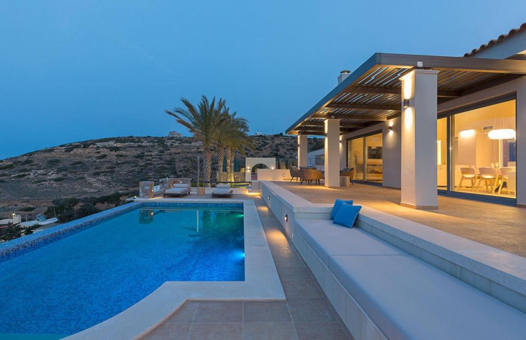 a villa with a swimming pool at night at Artisan's House in Sitia