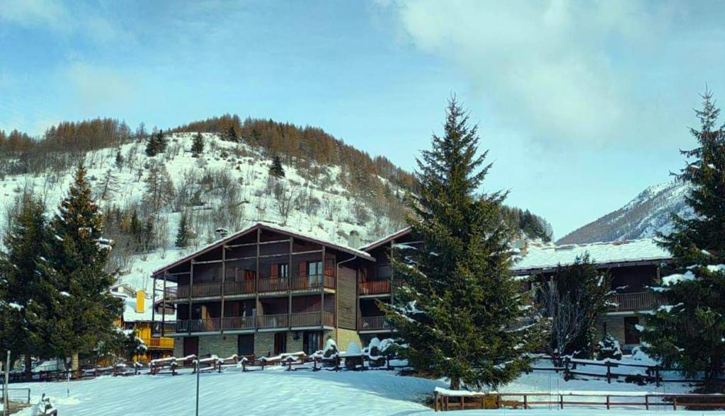 a large building in the snow in front of a mountain at La casa nel cuore di La Thuile in La Thuile