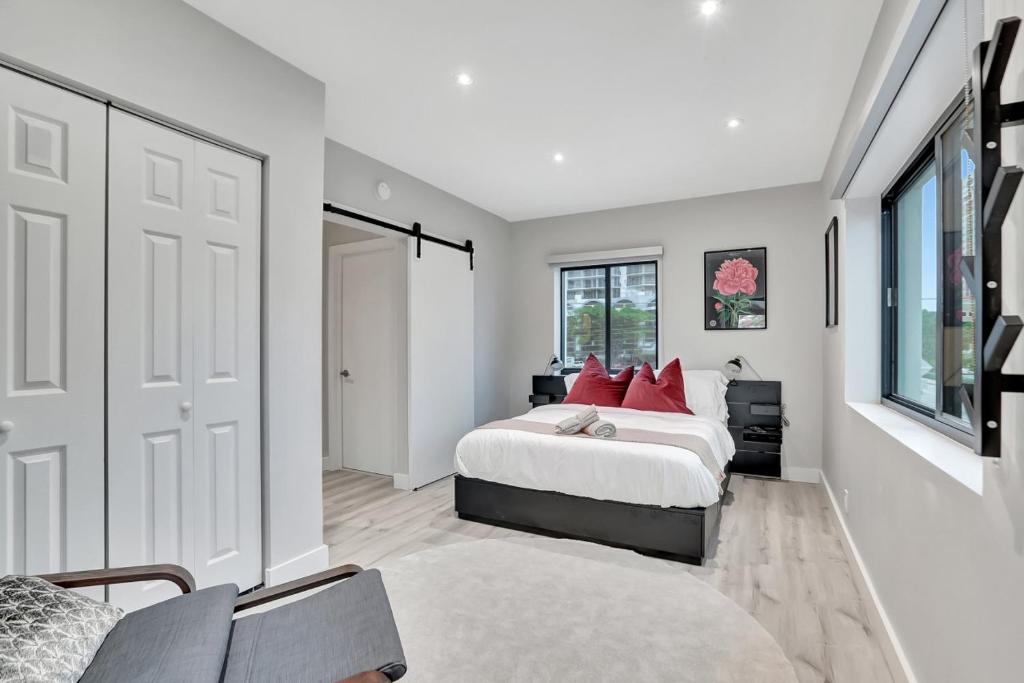 een slaapkamer met een groot bed met rode kussens bij Condo Right off Las Olas - Steps to FTL Beach 2A in Fort Lauderdale