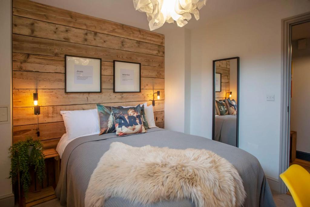 een slaapkamer met een bed met een grote witte deken bij higgihaus Cabot Mews #29 Sunday - Friday 3 night min in Bristol