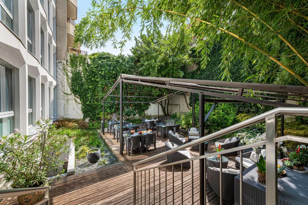une terrasse avec des tables et des chaises dans un bâtiment dans l'établissement Jade Manotel, à Genève