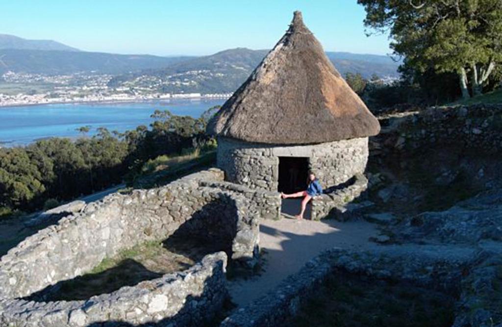 a person sitting in a small stone building at A Las faldas del Tecla in A Guarda