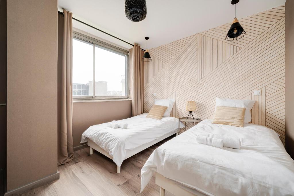 南錫的住宿－Vue sur le Palais - Nancy Gare Congrès - PARKING - T3，一间卧室设有两张床和窗户。
