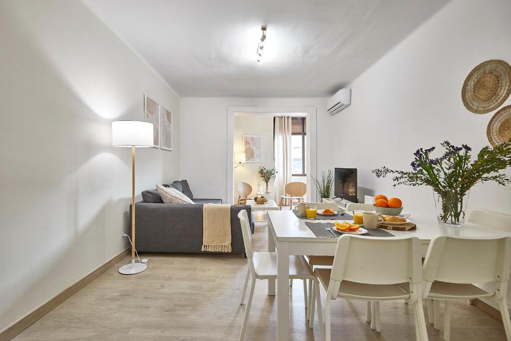 a dining room and living room with a table and chairs at BBarcelona Encants Flat in Barcelona