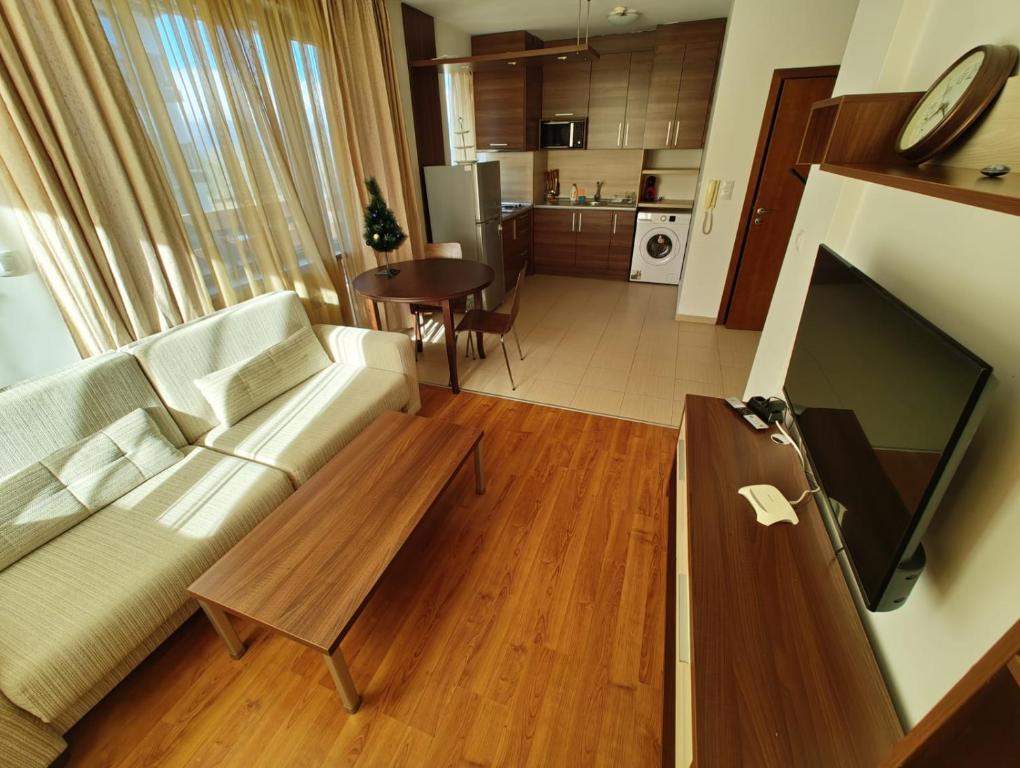 uma sala de estar com um sofá, uma televisão e uma mesa em Апартаменты в Belvedere em Bansko