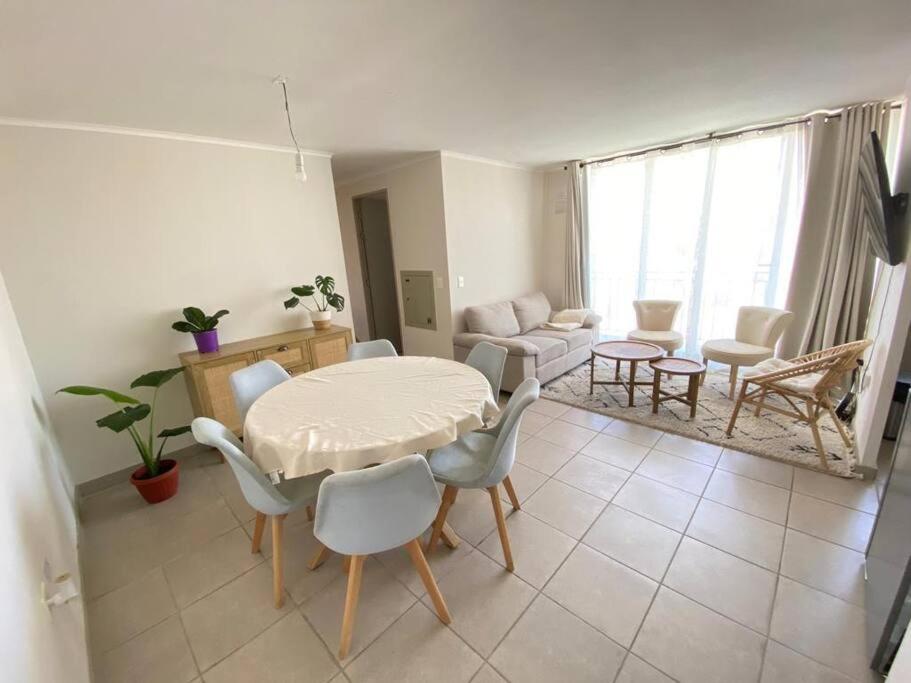 sala de estar con mesa, sillas y sofá en Apartamento en La Serena, Puertas del mar, en La Serena