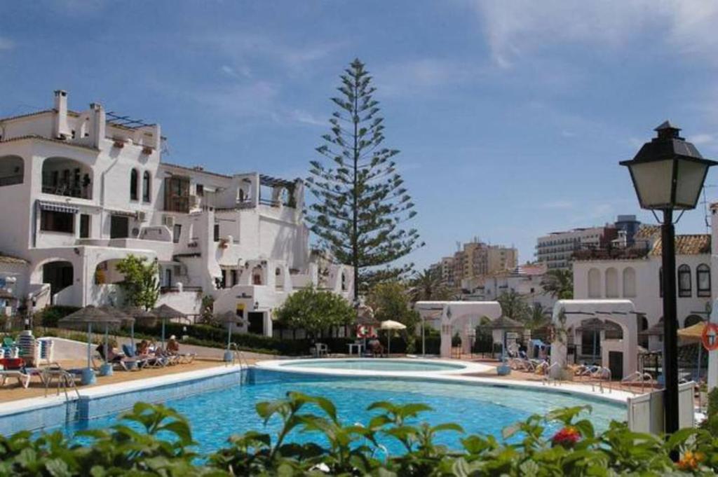 een groot zwembad voor een gebouw bij 2 bedroom apartment with pool and barbecue in Arroyo de la Miel