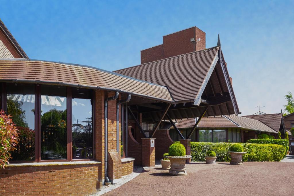 a brick building with a roof with windows and plants at Barton Manor Hotel & Spa; BW Signature Collection in Preston