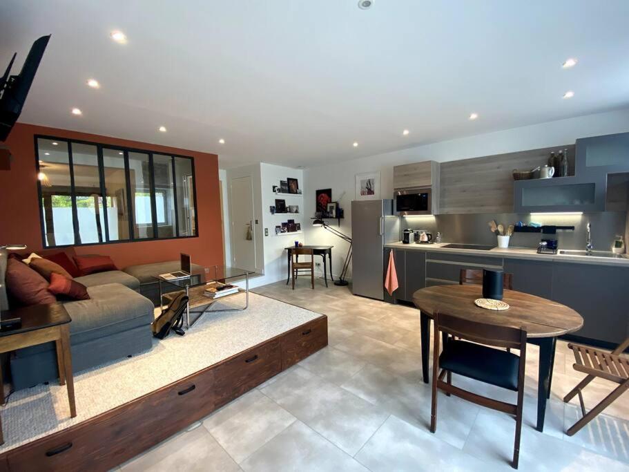 a living room and kitchen with a couch and a table at Le nuage des balmes in Caluire-et-Cuire