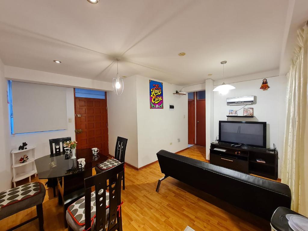 a living room with a couch and a tv and a table at Apartment Centric Inti 2 in Cusco