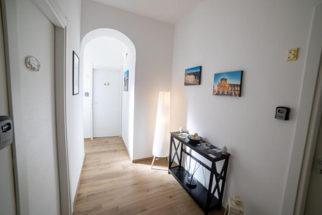 un pasillo con paredes blancas y suelo de madera en Residence Le Tre Piazze, en Siracusa