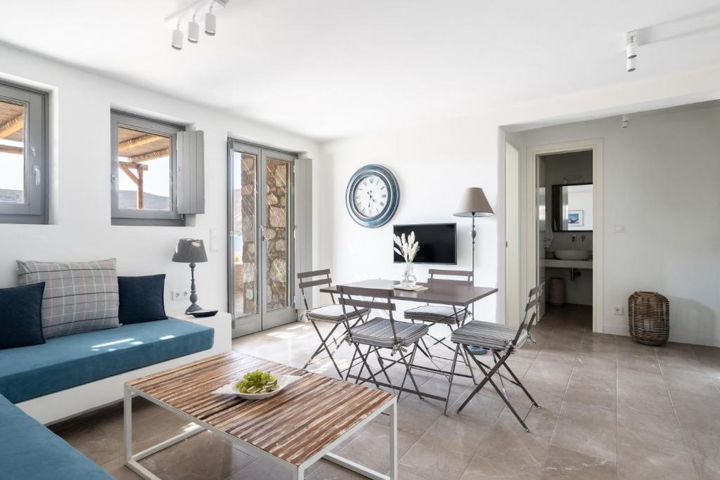 a living room with a blue couch and a table at Ammoa Beach Residences in Vayiá