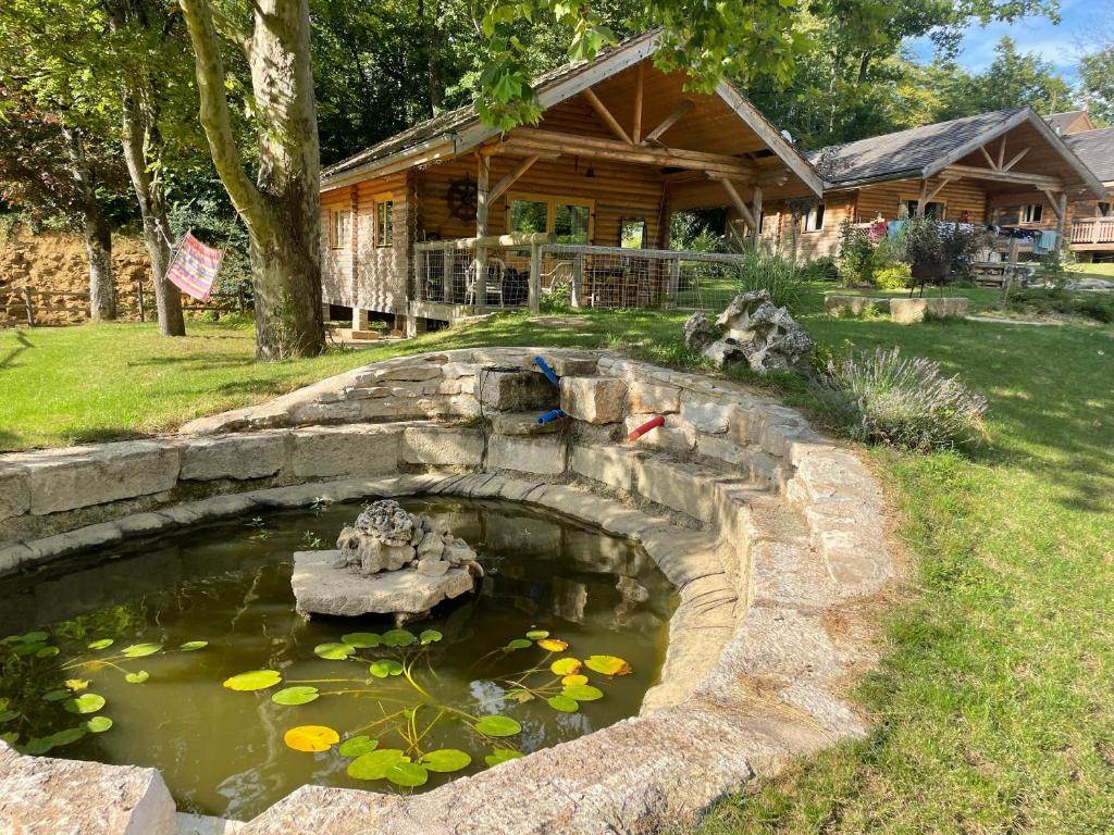 un estanque frente a una cabaña de madera en CHARMES en CHALET, en Charmes-lès-Langres