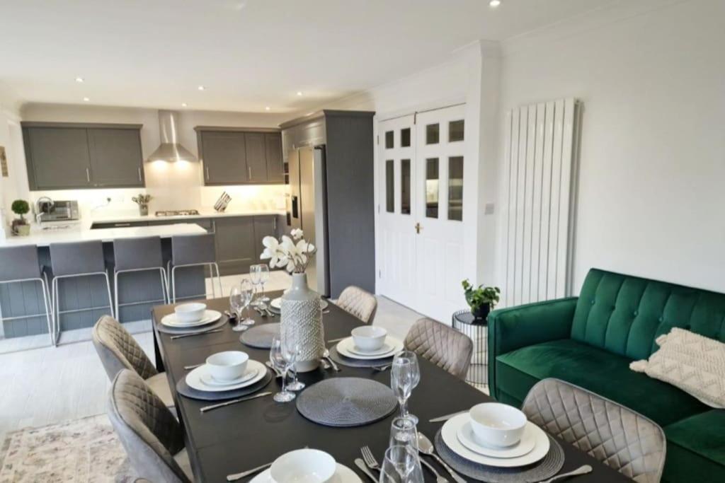 sala de estar con mesa y sofá verde en Beautifully done 5 bed barn conversion in Heswall - Sleeps up to 10, en Heswall