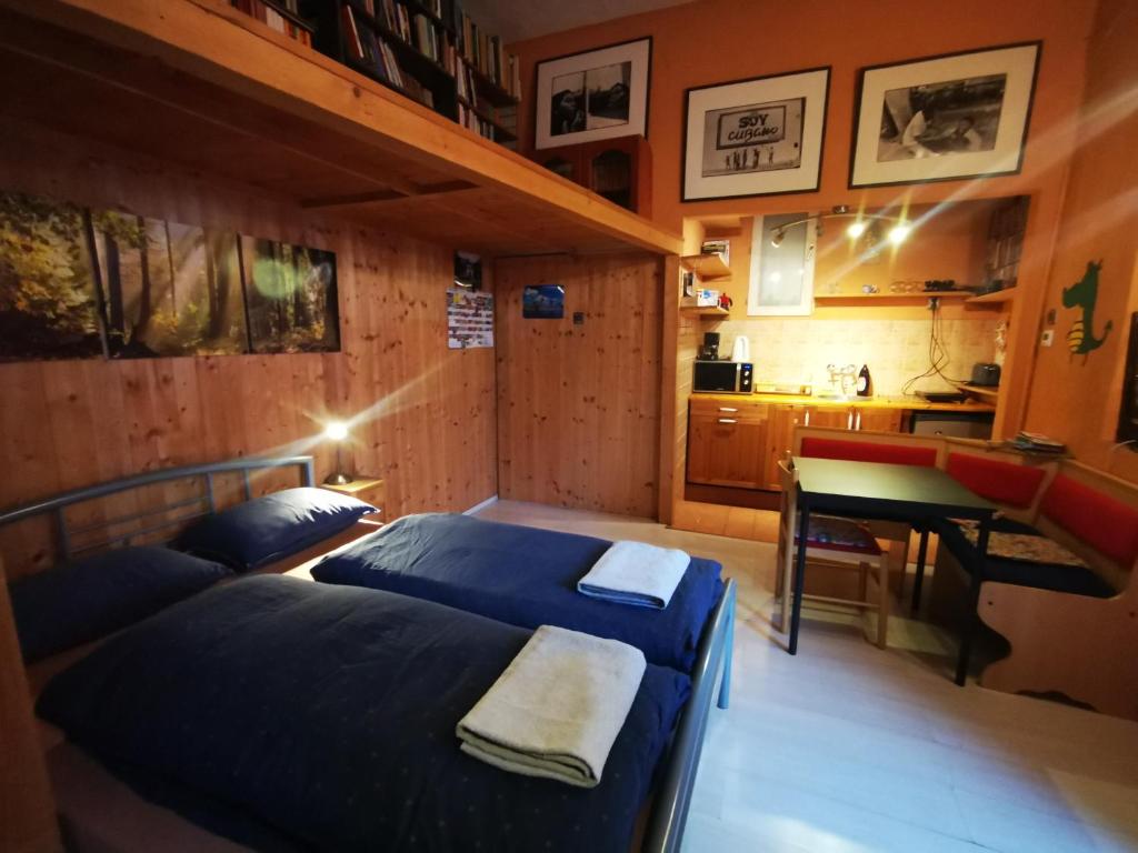 a bedroom with two beds and a table and a kitchen at High Sky Apartment in Budapest