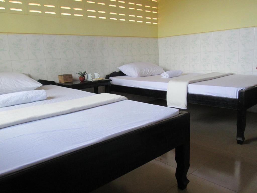 a room with three beds in a room at Homestay Chreav in Siem Reap