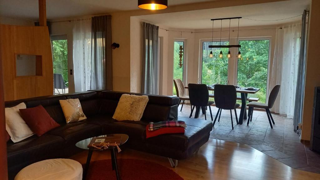 a living room with a couch and a dining room at Ferienwohnung Hammergrund in Mossautal