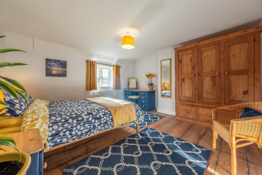 a bedroom with a bed and a blue rug at Wishing Well Cottage in North Creake
