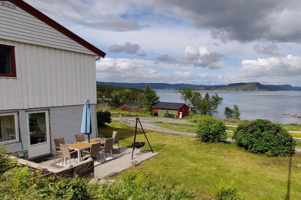 Casa con mesa, sillas y vistas al agua en Apartment Solbakken Feriehus, en Fevåg