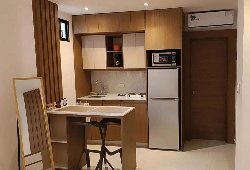 a kitchen with a white refrigerator and a table at NOVAPARK HOTEL in Guayaquil
