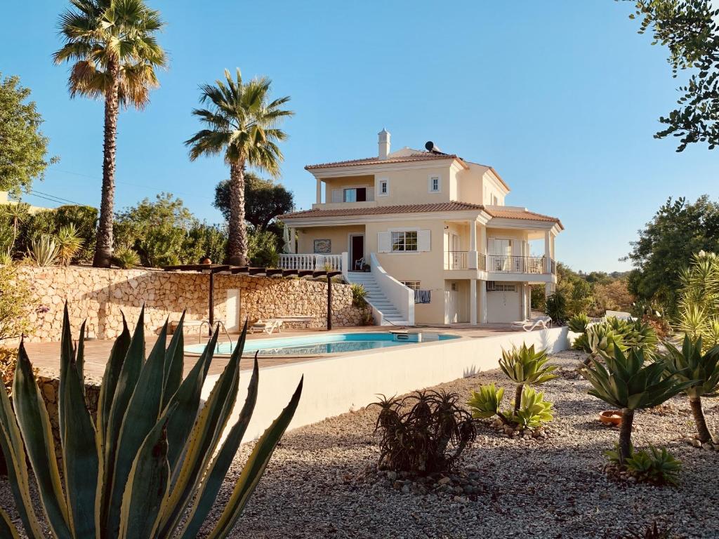 una casa con piscina y palmeras en Villa Botanica, en Silves