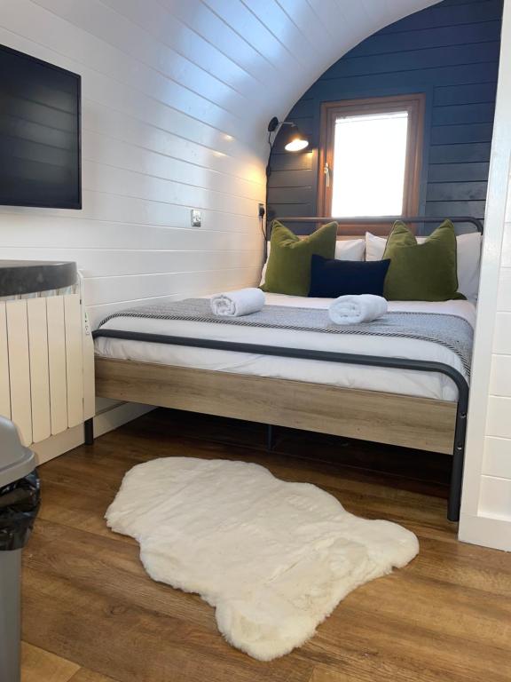 a bedroom with a large bed and a rug at Highland Stays - The Oaks Studio Pod in Fort William