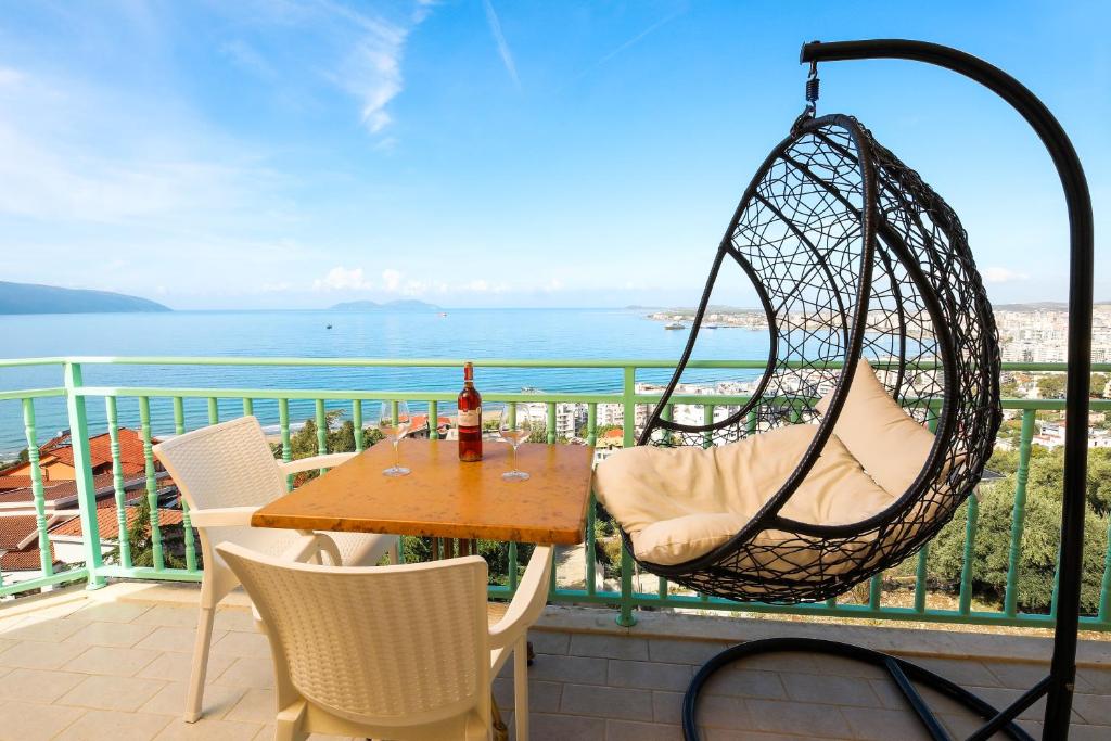 eine Terrasse mit einer Schaukel, einem Tisch und Stühlen in der Unterkunft Rezidenca Panorama Apartments in Vlorë