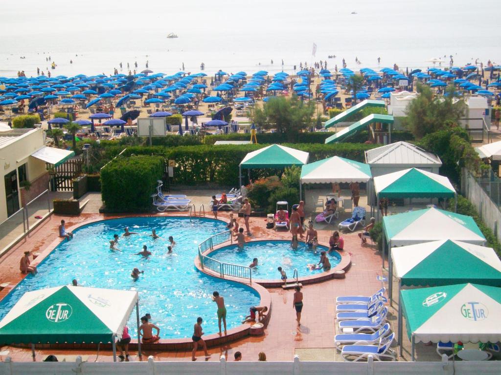 basen w ośrodku plażowym z osobami w nim w obiekcie Hotel Caravelle&MiniCaravelle w mieście Lido di Jesolo
