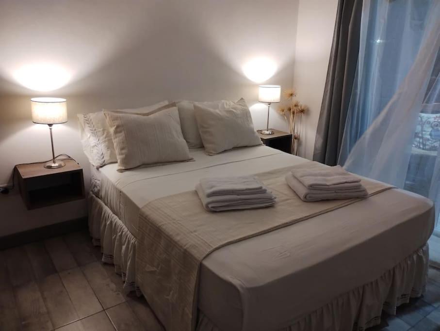 - une chambre avec un grand lit et deux lampes dans l'établissement Hospedaje La Bussola I, à Gualeguaychú