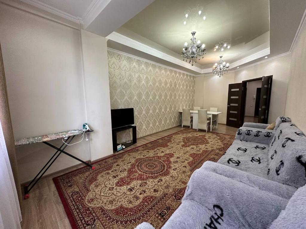 een woonkamer met een bank, een tv en een tafel bij apartment on st. Frunze 553 in Bisjkek