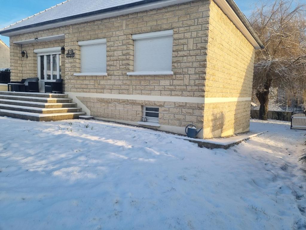 uma casa de tijolos com neve em frente em A la casa de papel em Neuilly-sous-Clermont
