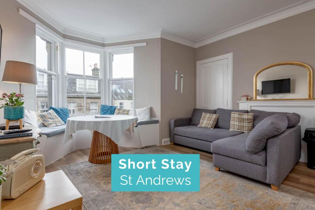 een woonkamer met een bank en een tafel bij 44 Argyle Street - 2 Bed-1 Bath - Central in St Andrews