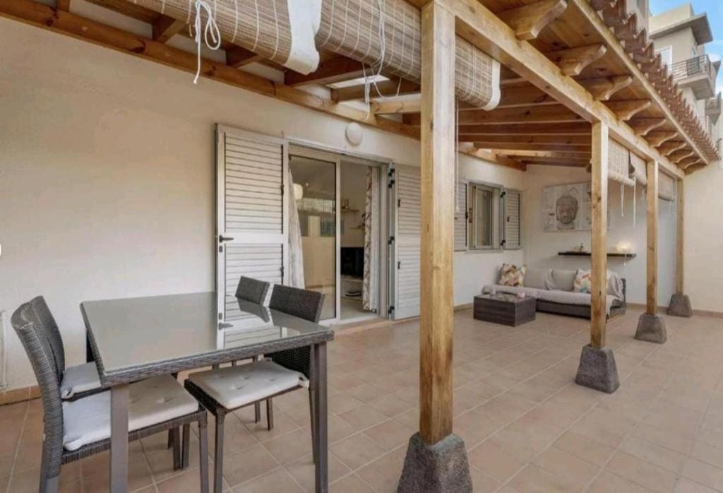 - une salle à manger avec une table, des chaises et un lit dans l'établissement Apartamento LiLi Beach, à Candelaria