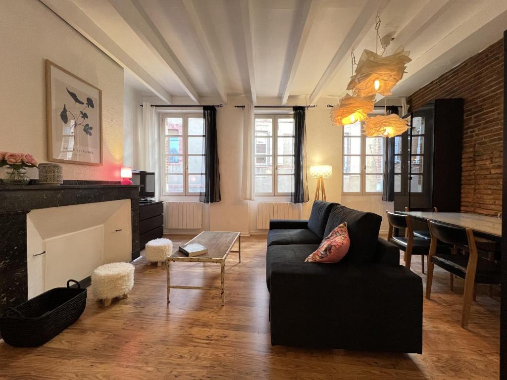 ein Wohnzimmer mit einem Sofa und einem Tisch in der Unterkunft Le Vogue - 4-6p - hypercentre-metro in Toulouse