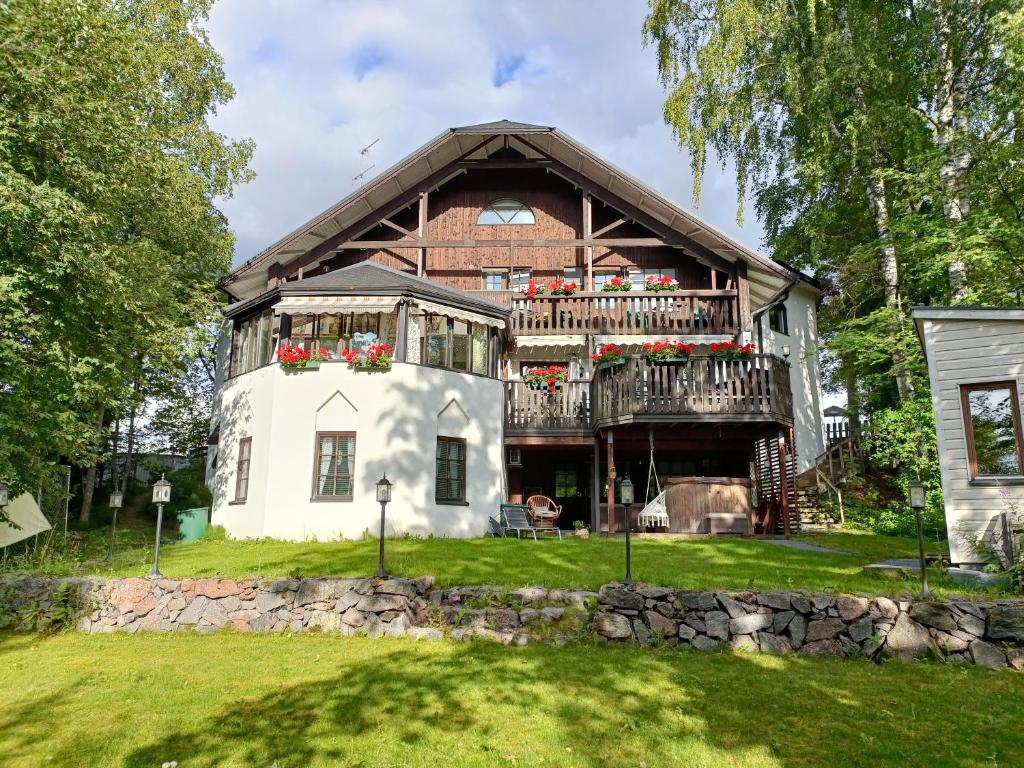 a large wooden house with a balcony on top at Cronin's Guesthouse B&B in Heinola