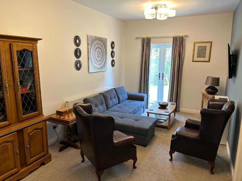 a living room with a blue couch and chairs at The Long Hall 2 bed ground floor annexed apartment - sleeps 6 in Chesterfield