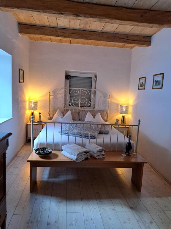 1 dormitorio con 1 cama y 1 mesa con 2 lámparas en CasaBleiberg - Garten Apartment - Naturpark Dobratsch en Bad Bleiberg