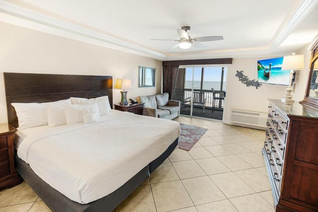 um quarto com uma cama grande e uma sala de estar em Dunes King Room Oceanfront Views em Pawleys Island