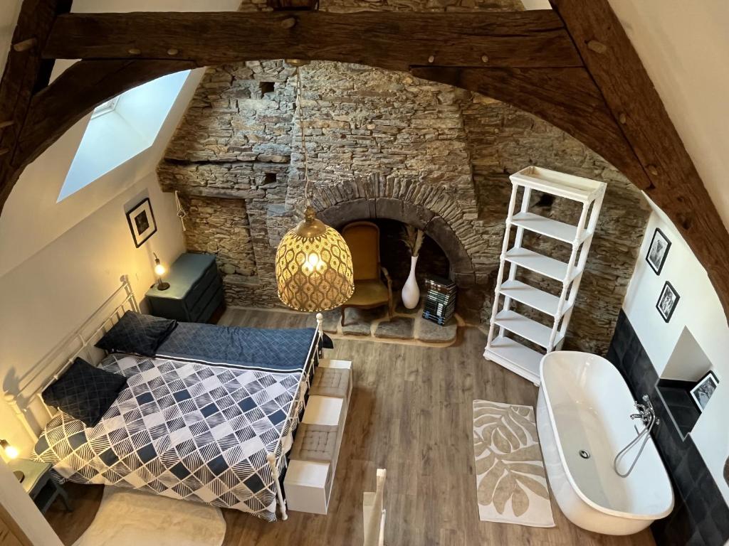 an overhead view of a bedroom with a stone wall at Maison de caractère, centre ville historique in Malestroit