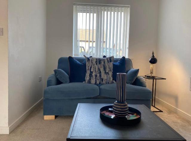 a living room with a blue couch and a table at Temper Mill 3 BR Garden & FREE parking in Newport