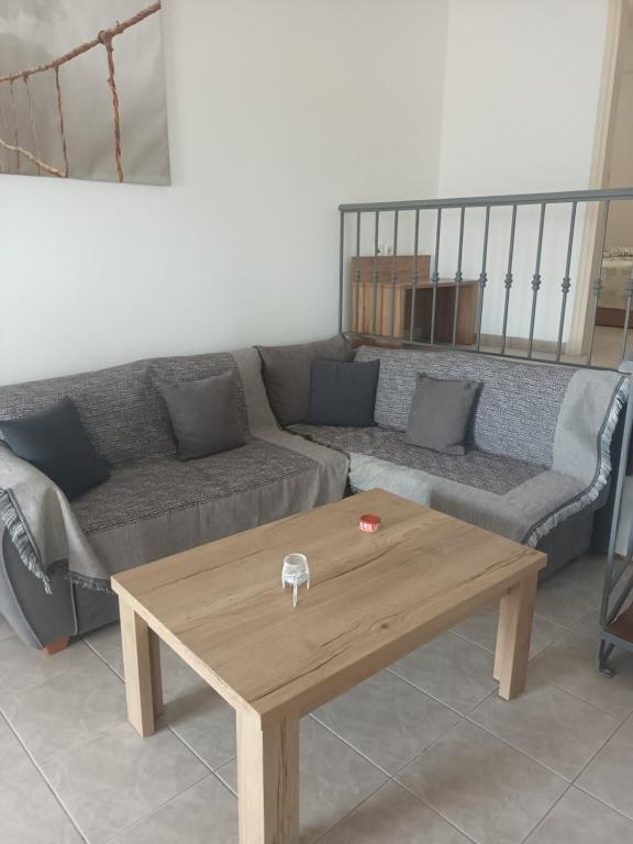 a living room with a couch and a wooden coffee table at Charoula's Apartments in Syvota