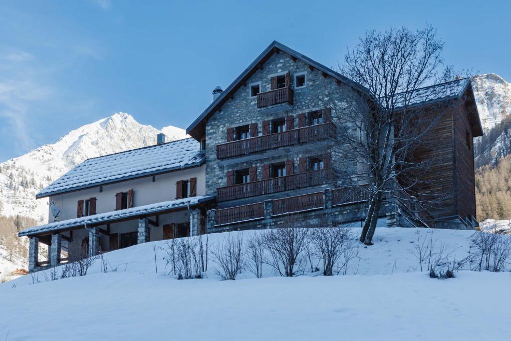 a large building in the snow in front of a mountain at Chalet du Bon Air in Peisey-Nancroix
